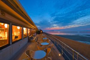 a balcony with tables and chairs and the ocean at GLAMPREMIER Setouchi in Kanonji