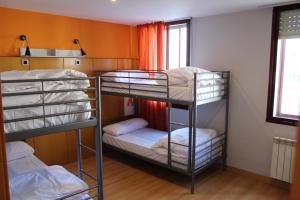布爾戈斯的住宿－Mola! Hostel Burgos，客房设有三张双层床和一扇窗户。