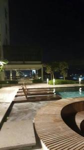 a row of benches next to a pool at night at Guest Studio/Suite Condominum Near Batu Caves in Batu Caves
