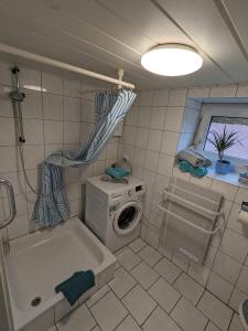 a bathroom with a washing machine and a washer at Huus Meta in Krummhörn