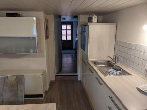 uma cozinha com um lavatório e uma bancada em Huus Meta em Krummhörn