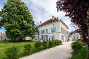 una gran casa blanca con un árbol delante en Qualisterra - Chambres d'Hôtes, Vignoble Bio-inspirant et Bien-être Corps et Esprit en Bar-sur-Aube