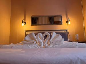 een bed met twee zwanen gemaakt van handdoeken bij PePi-Resort in Chiang Rai