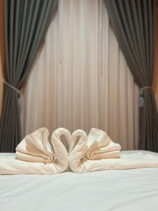 - une paire de chaussons assise au-dessus du lit dans l'établissement PePi-Resort, à Chiang Rai