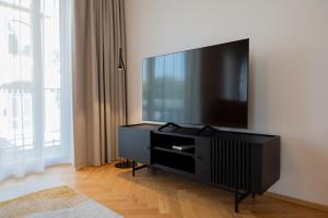 a flat screen tv sitting on top of a black entertainment center at Cozy Stay Apartment in Pärnu