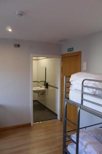 Zimmer mit einem Bett und einem Bad mit einem Waschbecken in der Unterkunft Mola! Hostel Burgos in Burgos