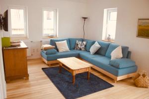 ein Wohnzimmer mit einem blauen Sofa und einem Tisch in der Unterkunft Sand 68 in Steinau an der Straße