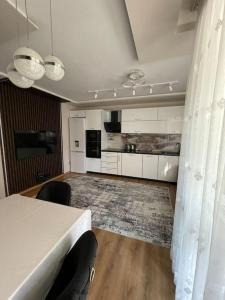 a living room with a table and a kitchen at Luxury Flat-4 People-Mladost in Varna City