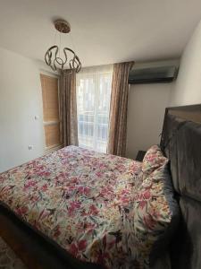 a bedroom with a large bed with a floral bedspread at Luxury Flat-4 People-Mladost in Varna City