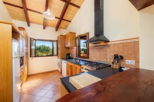 uma cozinha com armários de madeira e um forno com placa de fogão em Casa Coral - Cala Bona em Cala Bona