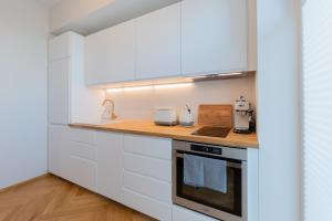 a kitchen with white cabinets and a counter top at Cozy Stay Apartment in Pärnu