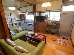 a living room with two chairs and a coffee table at 【MEMS】1人から貸切OK!駐車場1台付き!那覇空港から車で13分！ in Takara