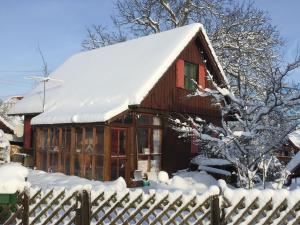 uma casa coberta de neve com uma cerca em Das Häusle em Neubulach