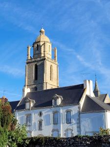 um edifício com uma torre de relógio em cima em LE NID DE BATZ SUR MER-Studio-Les Gîtes de la Côte d'Amour em Batz-sur-Mer