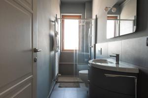 La salle de bains est pourvue d'un lavabo, de toilettes et d'un miroir. dans l'établissement Casa No.Na - Attico panoramico a Cherasco, à Cherasco