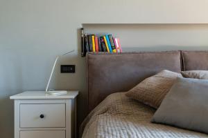 ein Schlafzimmer mit einem Bett und einem Nachttisch mit Büchern darauf in der Unterkunft Casa No.Na - Attico panoramico a Cherasco in Cherasco