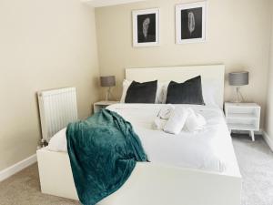 a bedroom with a white bed and two night stands at Brand New 1 Bed with Sofabed, Private Patio & Electric Parking Bay, 5min Walk to Racing & Main Strip LONG STAY WORK CONTRACTOR LEISURE - AMBER in Newmarket