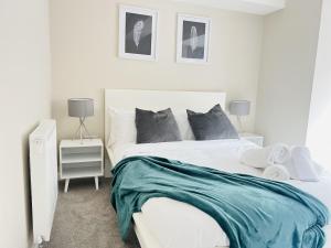 a bedroom with a white bed with a blue blanket at Brand New 1 Bed with Sofabed, Private Patio & Electric Parking Bay, 5min Walk to Racing & Main Strip LONG STAY WORK CONTRACTOR LEISURE - AMBER in Newmarket