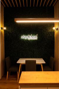 a restaurant with two tables and a sign on a wall at Stay & Heal Apartman in Rogaška Slatina