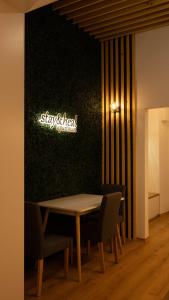 Stay & Heal Apartman في روغاسكا سلاتينا: طاولة وكراسي على جدار