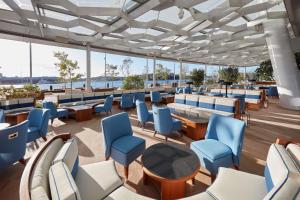 a restaurant with blue chairs and tables on a ship at Crown Towers Sydney in Sydney