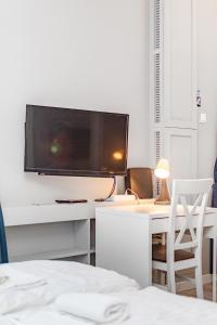 a bedroom with a desk with a television on a wall at Elektoralna 19 by Homeprime in Warsaw
