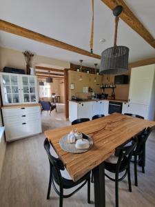 a kitchen and dining room with a wooden table and chairs at Family holiday house near to Baltic sea in Pitrags "JAUNZUMBRI" in Pitragutsiyeme