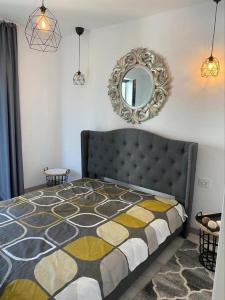 une chambre avec un lit avec un miroir au mur dans l'établissement Apartament Happy Sea View, à Mamaia Nord – Năvodari