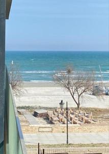 une plage avec un tas de chaises et l'océan dans l'établissement Apartament Happy Sea View, à Mamaia Nord – Năvodari