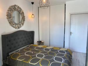 une chambre avec un lit et un miroir dans l'établissement Apartament Happy Sea View, à Mamaia Nord – Năvodari