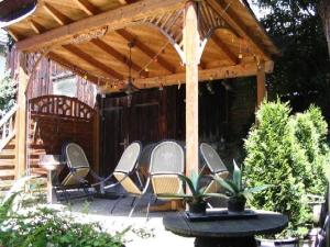 a wooden pergola with chairs and a table at Ferienhaus Villa Marina in Bad Urach