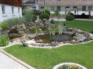 a garden with a pond in the middle of a yard at Ferienhaus Villa Marina in Bad Urach