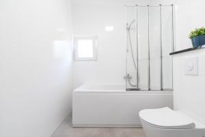 biała łazienka z wanną i toaletą w obiekcie The Plaza Apartment w mieście Prižba +28 zdjęć