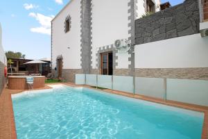 a swimming pool in front of a building at Casa Barriguita in Yaiza