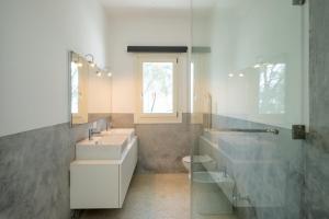 a bathroom with two sinks and a toilet and a window at Ocean View Penthouse with Jacuzzi Elias Homes ZanzibarHouses in Gulioni +38 photos