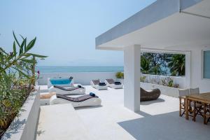 un patio con sedie, tavoli e l'oceano di Ocean View Penthouse with Jacuzzi Elias Homes ZanzibarHouses a Gulioni
