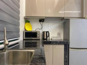 a kitchen with a sink and a microwave at Home Sweet Home 2 rooms Apartment in Melaka