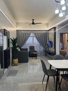 a living room with a ceiling fan and tables and chairs at Home Sweet Home 2 rooms Apartment in Melaka