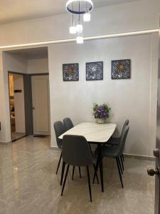 a dining room with a white table and chairs at Home Sweet Home 2 rooms Apartment in Melaka