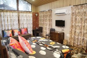 een woonkamer met een bank en een flatscreen-tv bij Seaswan resort in Alibaug