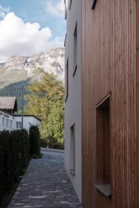 a stone walkway between two buildings with a mountain in the background at Casa Flurina in Flims