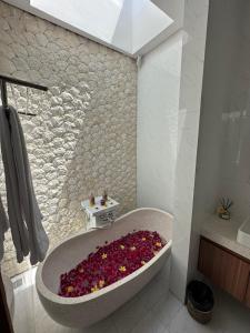 ein Badezimmer mit einer mit Blumen gefüllten Badewanne in der Unterkunft Bali Bird Villa in Seminyak