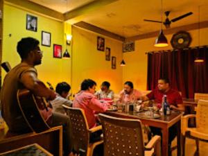a group of people sitting around a table in a restaurant at JMT Eco-Binsar Dhaulchhina in Panuānaula