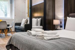 einen Haufen Handtücher auf einem Bett in einem Zimmer in der Unterkunft Circlelet Luxury Private Suite 1 in London