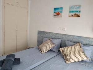 1 dormitorio con 1 cama azul y 2 almohadas en Apartamento con piscina junto a la playa, en Sant Antoni de Calonge