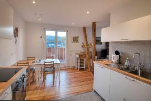 a kitchen with white cabinets and a wooden floor at Zum Alten Wärterhaus in Forbach