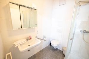 a white bathroom with a sink and a toilet at Appartement im Zentrum von Baienfurt in Baienfurt