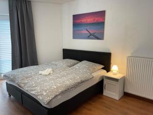 a bedroom with a bed and a night stand with a lamp at Appartement im Zentrum von Baienfurt in Baienfurt