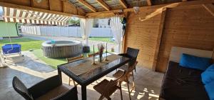 a patio with a table and chairs and a hot tub at Cazare Summer in Petroşani