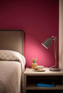 a lamp on a table next to a bed at Tetide Home in Palermo